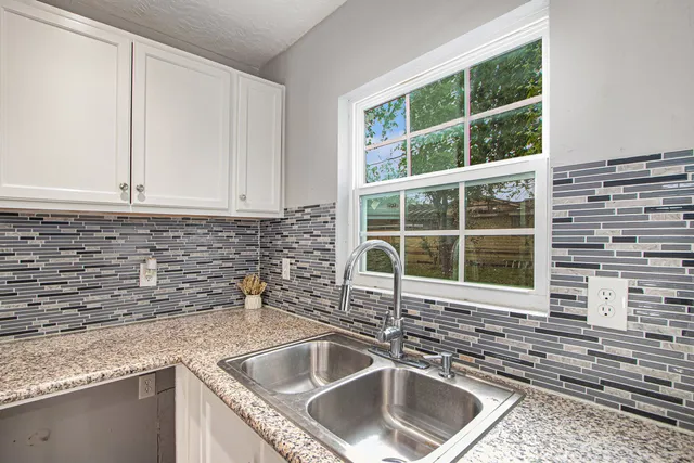 a kitchen with granite countertop a sink and a window