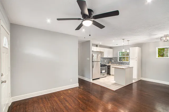 an empty room with wooden floor a ceiling fan and closet