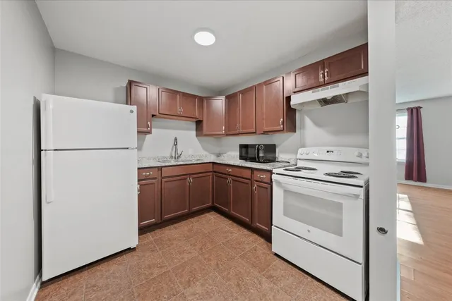 a kitchen with a refrigerator sink stove and cabinets