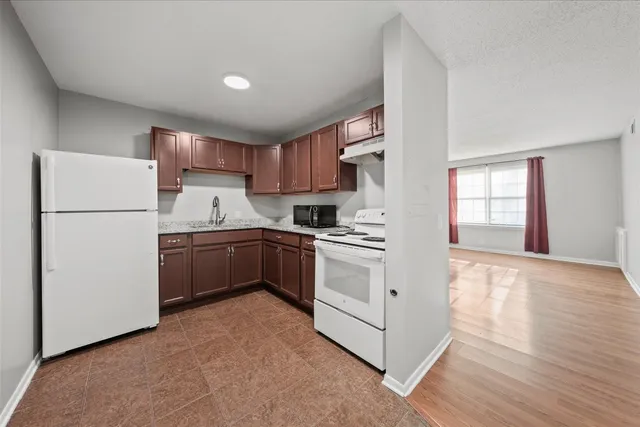 a kitchen with a refrigerator sink and cabinets