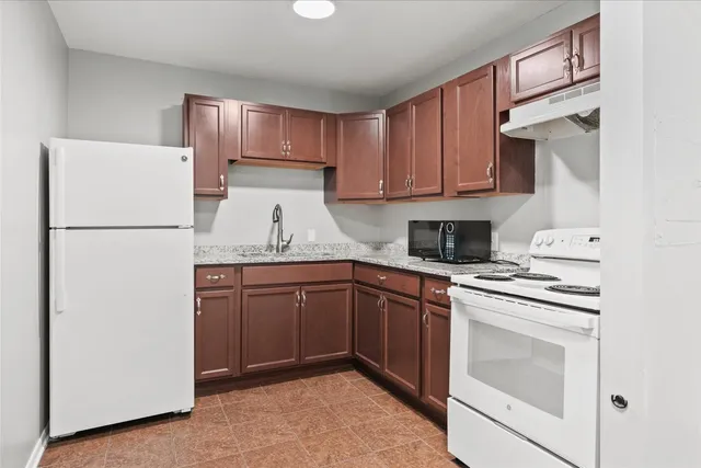 a kitchen with a refrigerator sink stove and cabinets