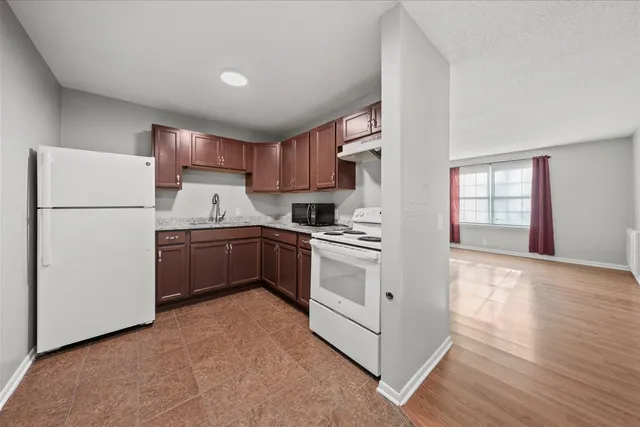 a kitchen with a refrigerator sink and cabinets