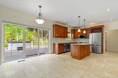 a large kitchen with kitchen island a large counter top stainless steel appliances and cabinets