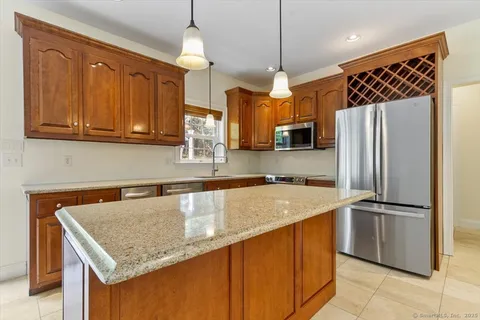 a kitchen with stainless steel appliances granite countertop a sink refrigerator and microwave