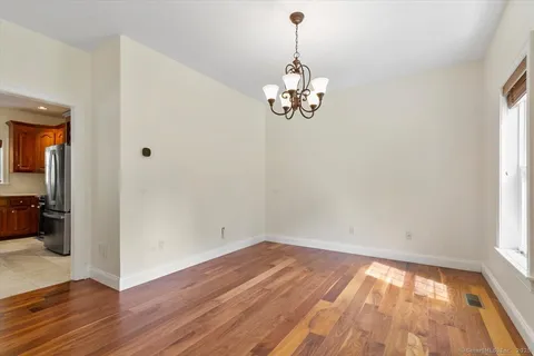 a view of empty room with wooden floor and window