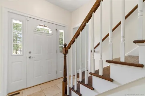 a view of an entryway with wooden floor and stairs