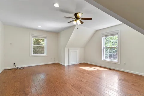 a view of an empty room with a window and wooden floor