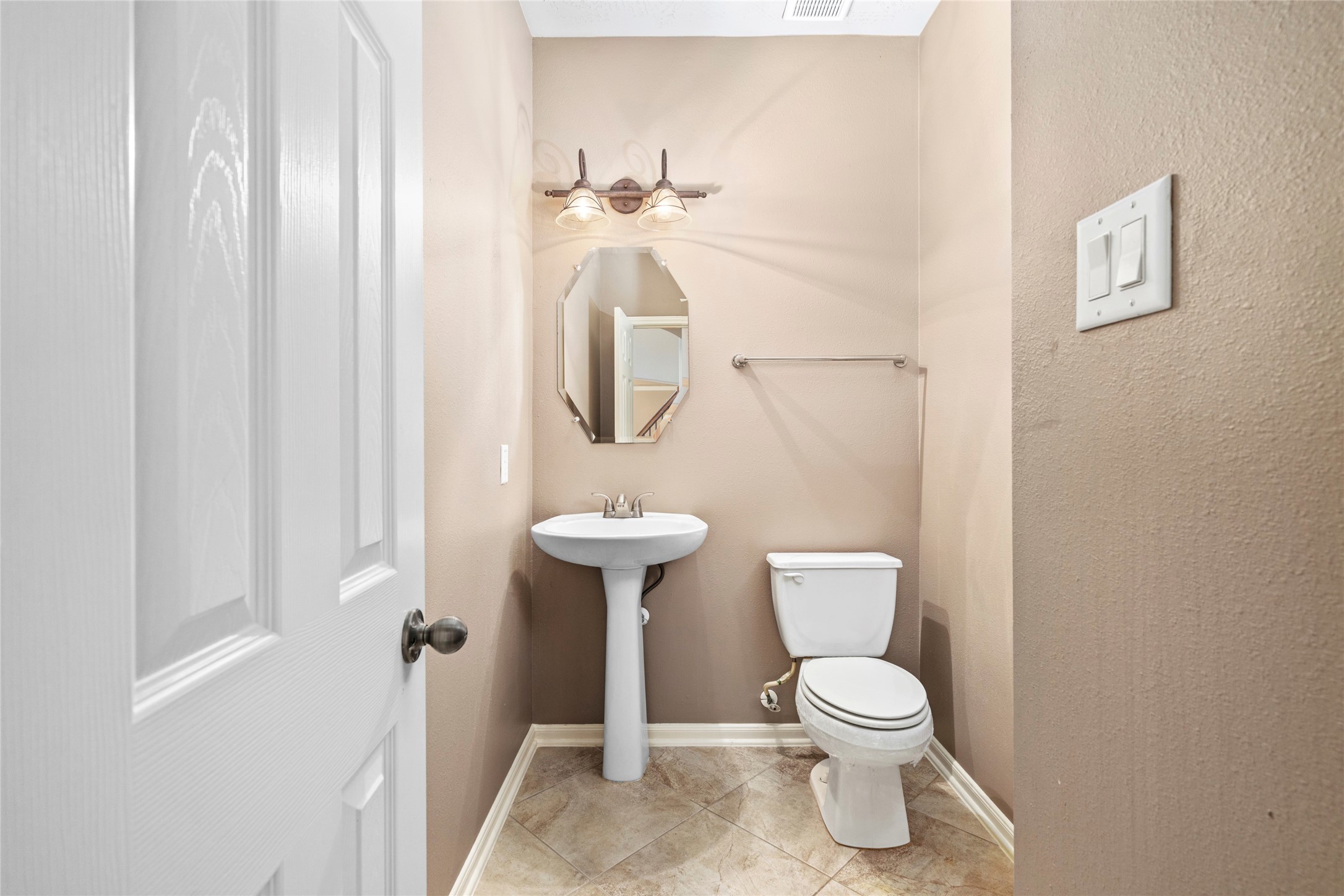 5307 Amber Sky Lane Rosharon, TX 77583 - Photo 28 of 50 A chic powder bath welcomes guests with a graceful pedestal sink, designer octagonal mirror, and warm tile flooring, refined convenience on the main floor.