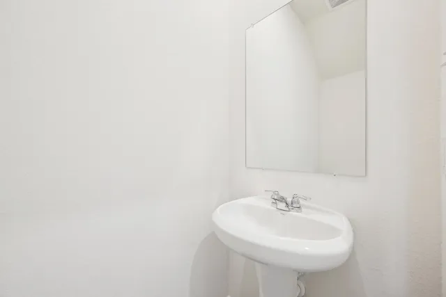 a white toilet sitting next to a white wall