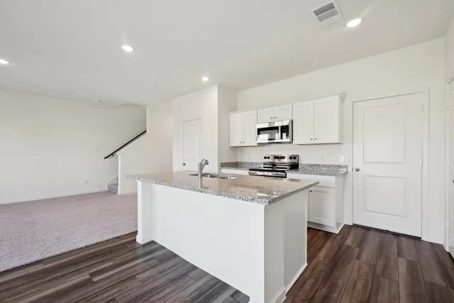 a kitchen with stainless steel appliances granite countertop a sink stove and refrigerator