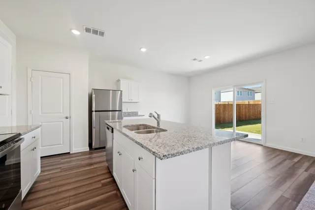 a kitchen with stainless steel appliances granite countertop a sink stove and refrigerator