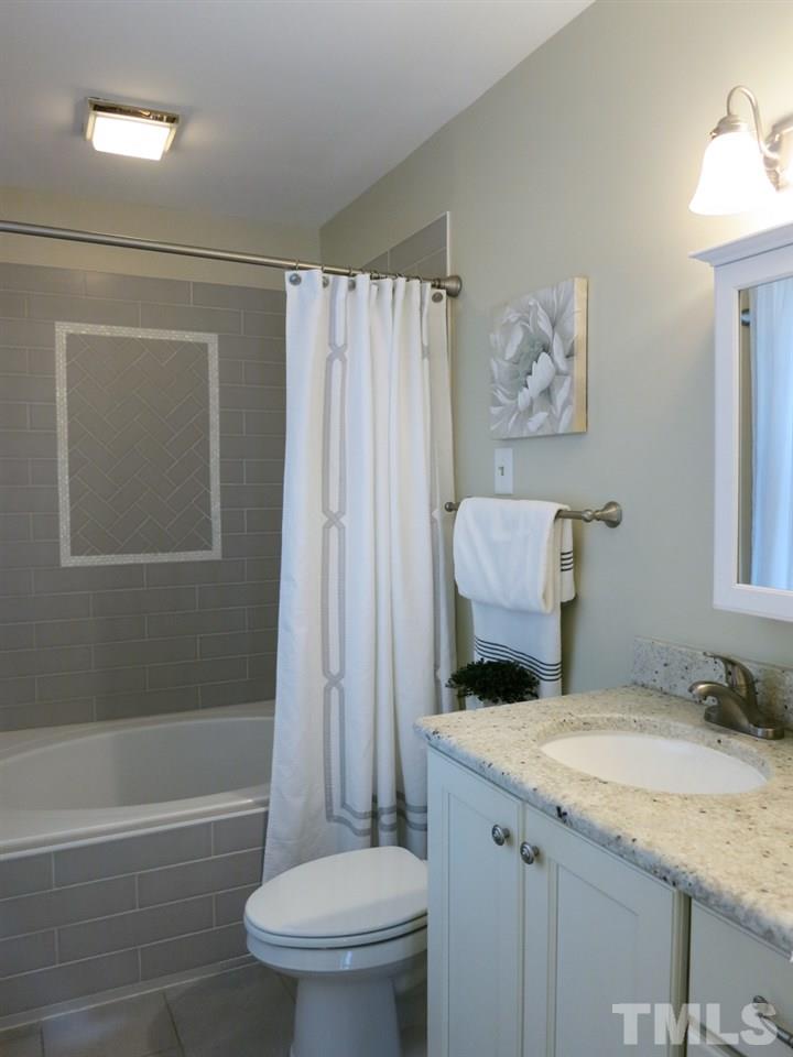 704 Currituck Drive Raleigh, NC 27609 - Photo 15 of 25 a bathroom with a granite countertop toilet and a sink