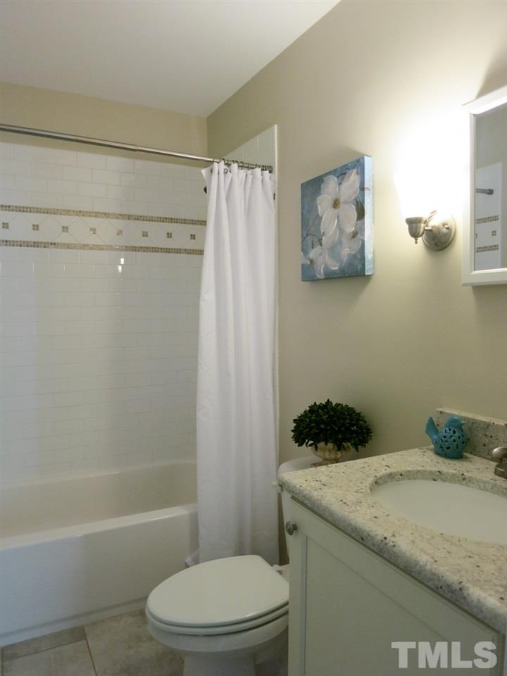 704 Currituck Drive Raleigh, NC 27609 - Photo 17 of 25 a bathroom with a granite countertop toilet and a shower