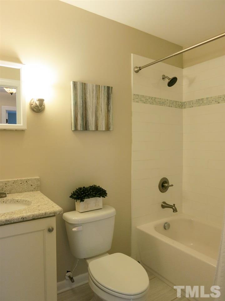 704 Currituck Drive Raleigh, NC 27609 - Photo 20 of 25 a bathroom with a granite countertop toilet a sink and a bathtub