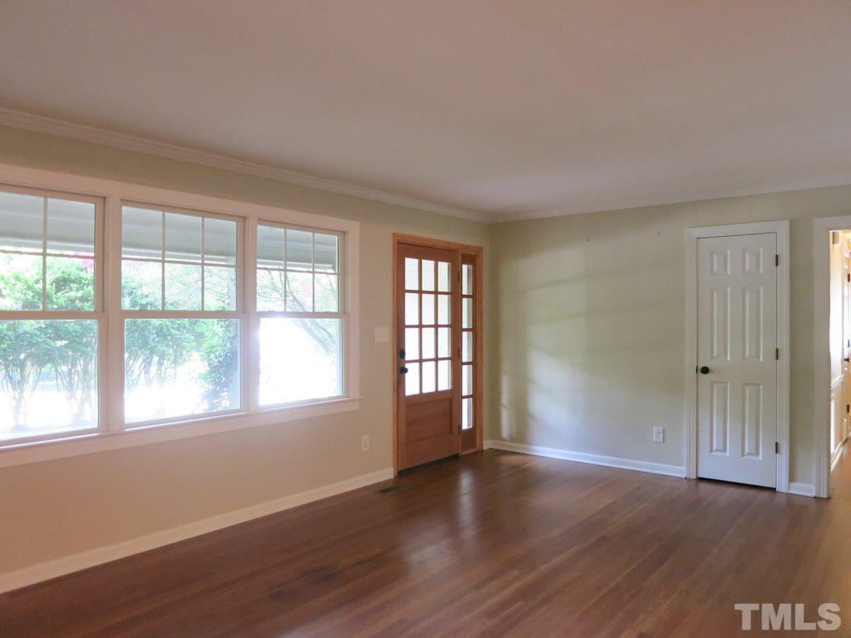 704 Currituck Drive Raleigh, NC 27609 - Photo 3 of 25 a view of an empty room with wooden floor and a window