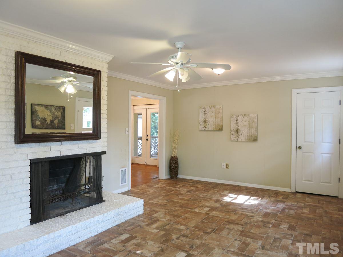 704 Currituck Drive Raleigh, NC 27609 - Photo 8 of 25 an empty room with windows and fireplace