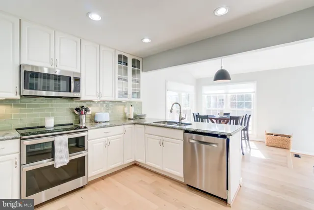 a kitchen with stainless steel appliances granite countertop a sink and stove top oven