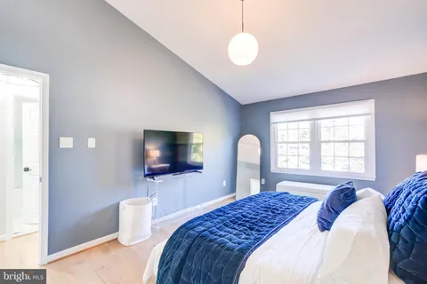 a bedroom with a bed a window and a television