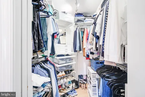 a view of walk in closet with clothes