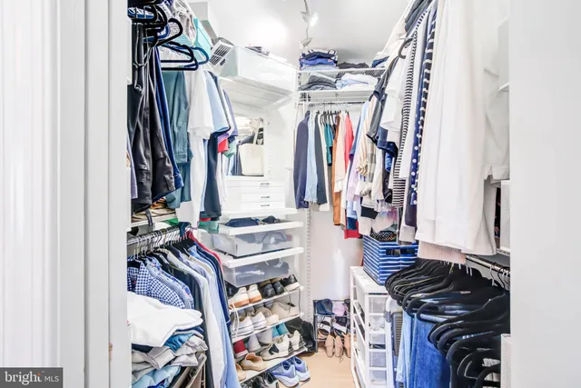 a view of walk in closet with clothes
