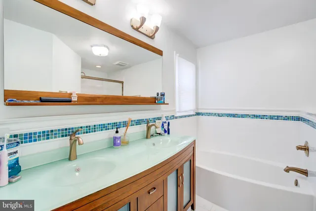 a bathroom with a sink a mirror and a bathtub