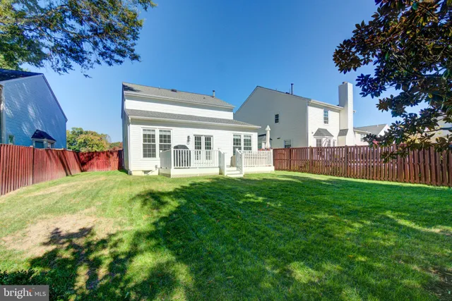 a view of a backyard with plants and wooden fence