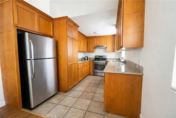 a kitchen with stainless steel appliances granite countertop a refrigerator and a sink