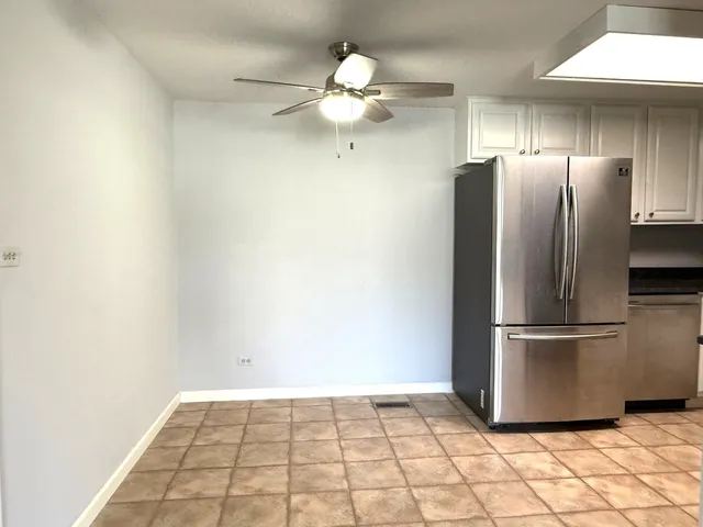 a kitchen with granite countertop a refrigerator and a stove top oven