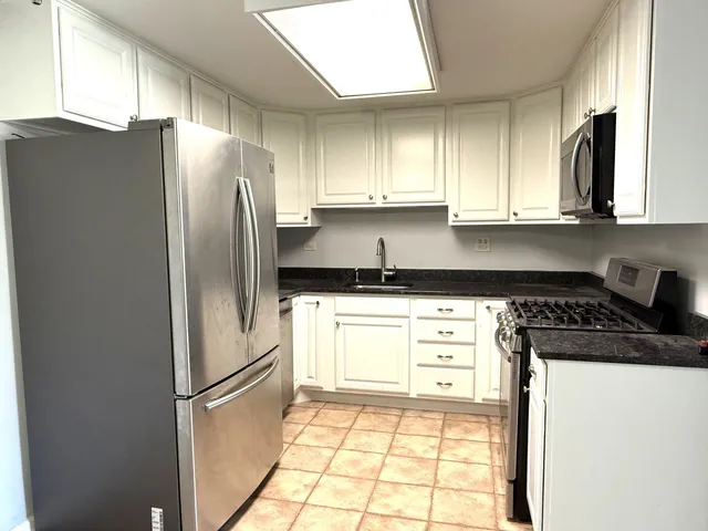 a kitchen with a refrigerator a stove a sink and a window