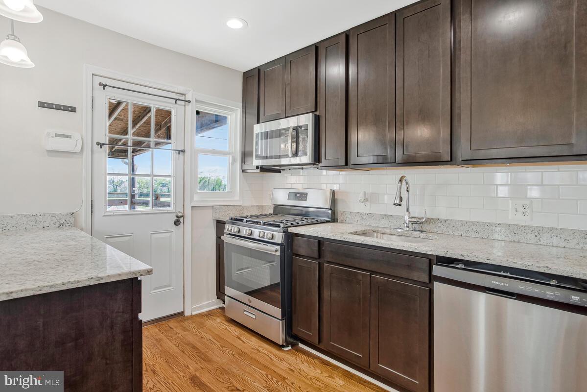 8352 Kavanagh Road Dundalk, MD 21222 - Photo 11 of 32 a kitchen with stainless steel appliances granite countertop wooden cabinets a sink and a stove