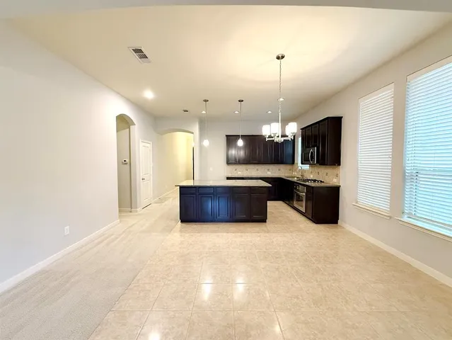 a large kitchen with a sink and cabinets