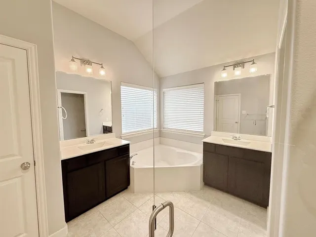 a bathroom with a bathtub sink and mirror