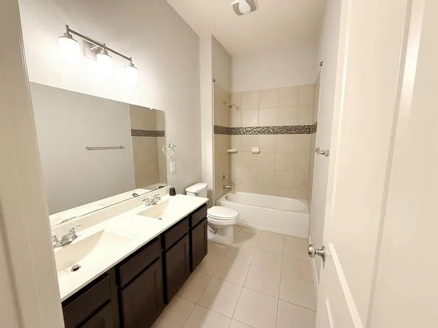 a bathroom with a tub sink shower and two mirror