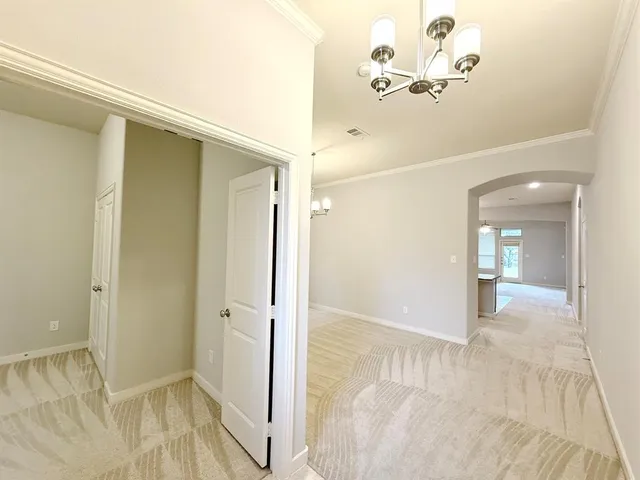 a view of a hallway with wooden floor and a bathroom
