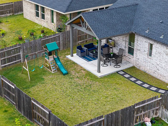 a view of a patio with couches table and chairs under an umbrella