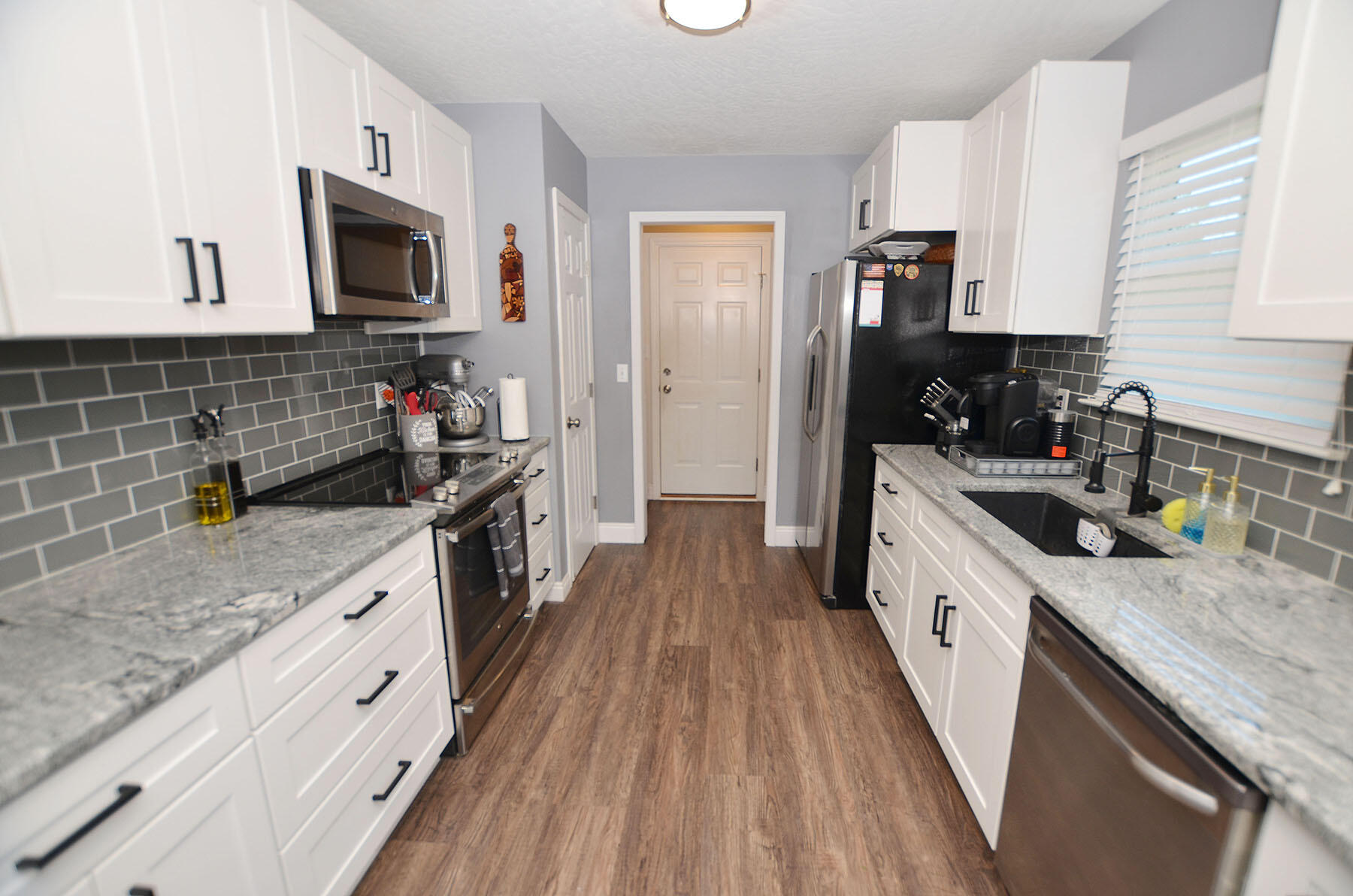 8271 Tavira Street Navarre, FL 32566 - Photo 12 of 60 a kitchen with granite countertop a stove top oven a sink dishwasher and a refrigerator