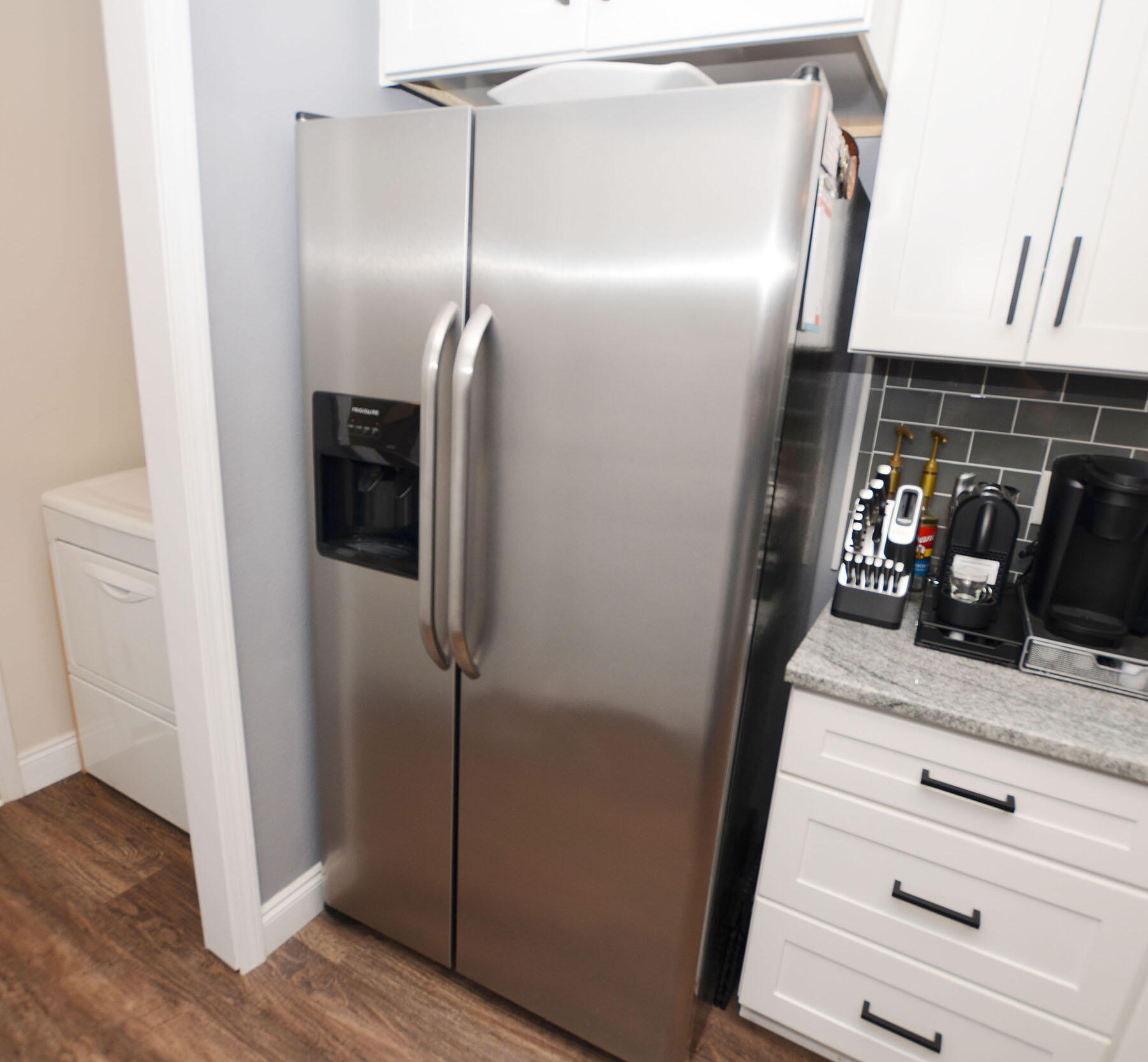 8271 Tavira Street Navarre, FL 32566 - Photo 20 of 60 a kitchen with a refrigerator and wooden floor