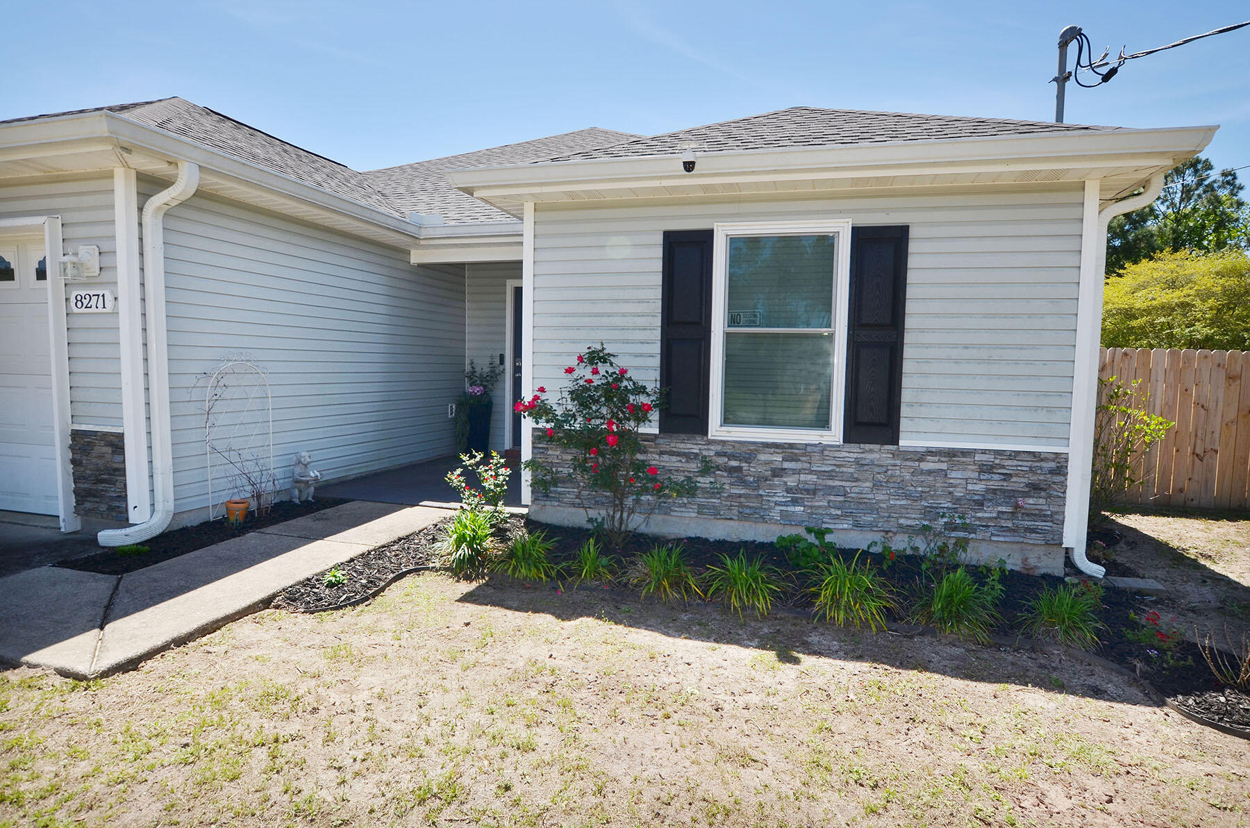 8271 Tavira Street Navarre, FL 32566 - Photo 4 of 60 a front view of a house with garden