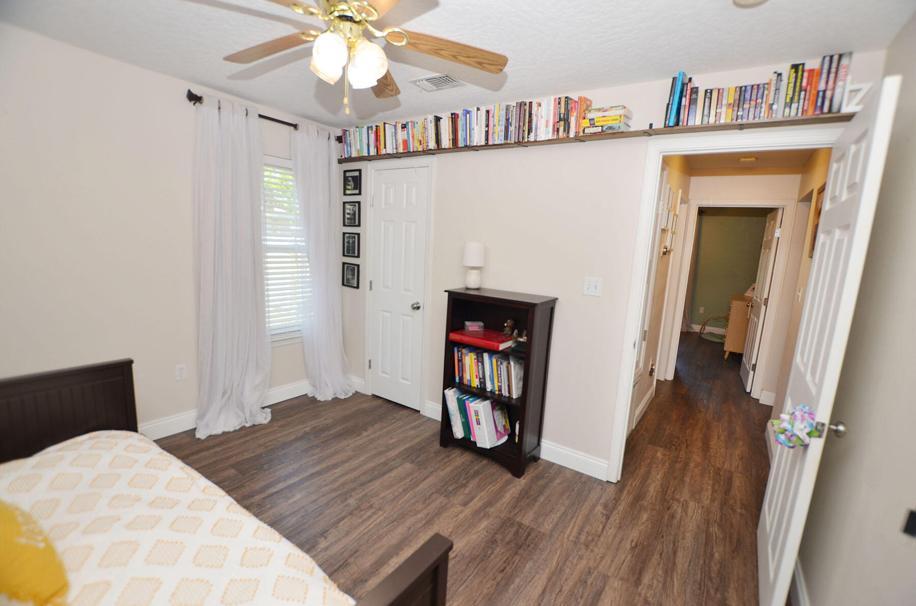 8271 Tavira Street Navarre, FL 32566 - Photo 42 of 60 a bedroom with furniture and a book shelf