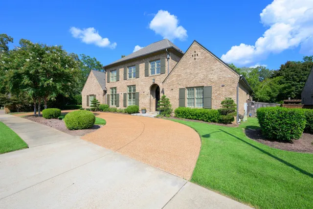 a view of house with garden and tall trees