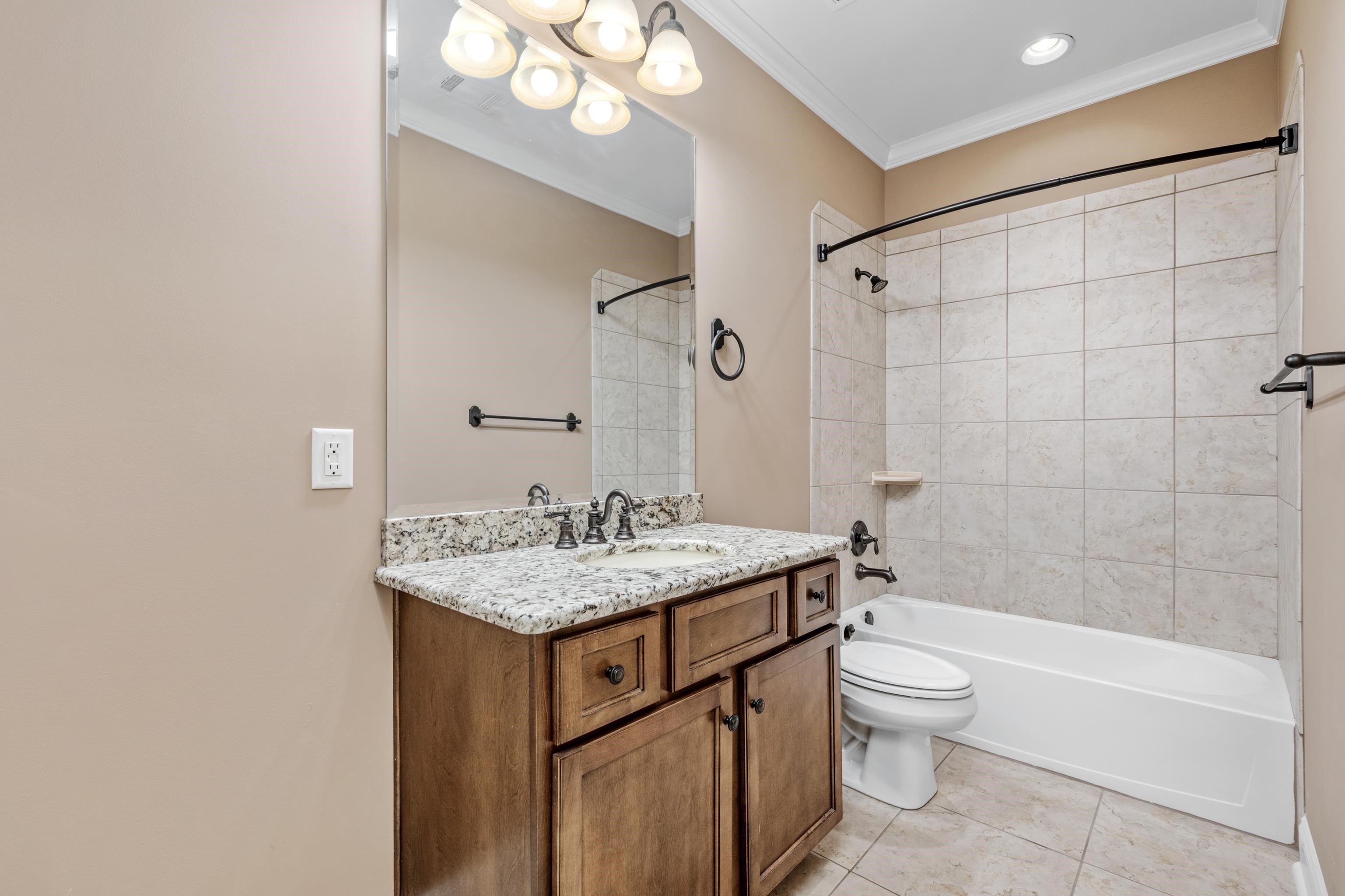 2840 Rue Jordan Cove Germantown, TN 38138 - Photo 33 of 40 a bathroom with a granite countertop sink a toilet a mirror and bathtub