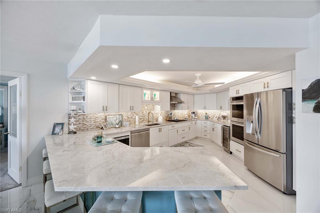 840 South Collier Boulevard, Unit 1104 Marco Island, FL 34145 - Photo 16 of 50 a kitchen with refrigerator and chairs