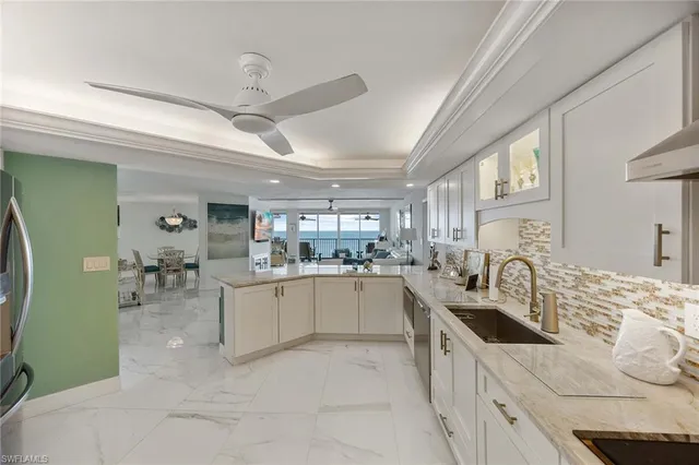 a spacious bedroom with a bed a large window with table and chairs