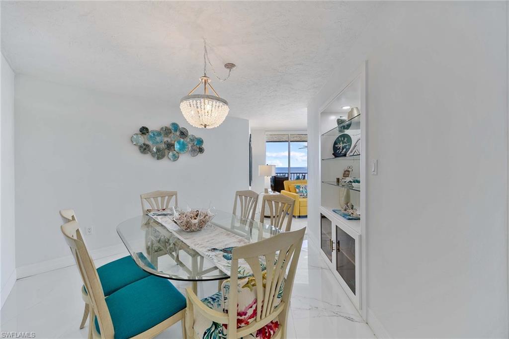 840 South Collier Boulevard, Unit 1104 Marco Island, FL 34145 - Photo 25 of 50 a view of a dining room with furniture and chandelier