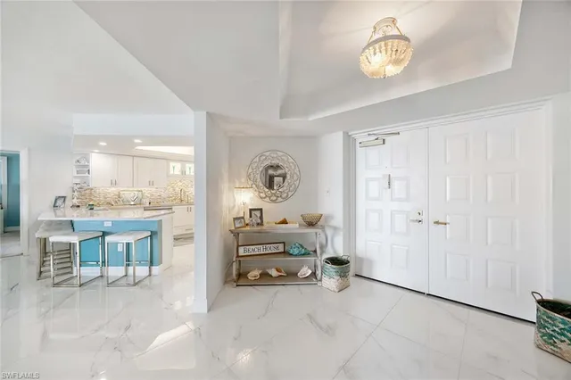 a view of a kitchen with refrigerator and white cabinets