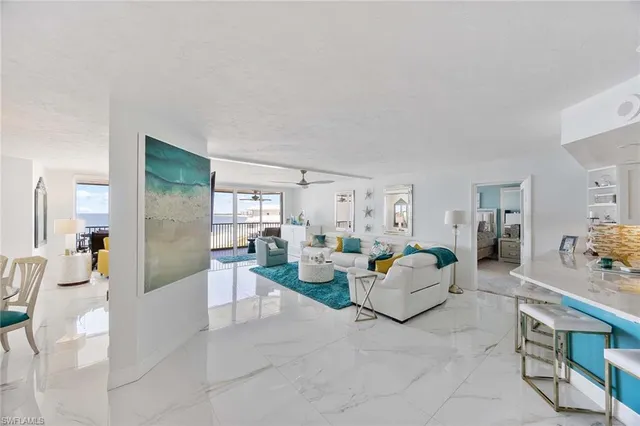 a living room with furniture and a kitchen view