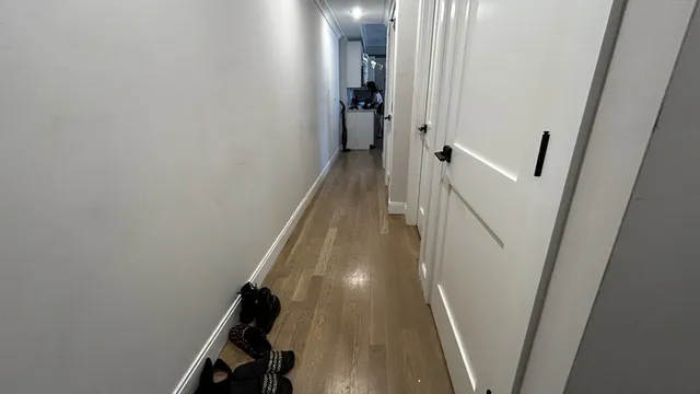a view of a hallway with wooden floor and staircase