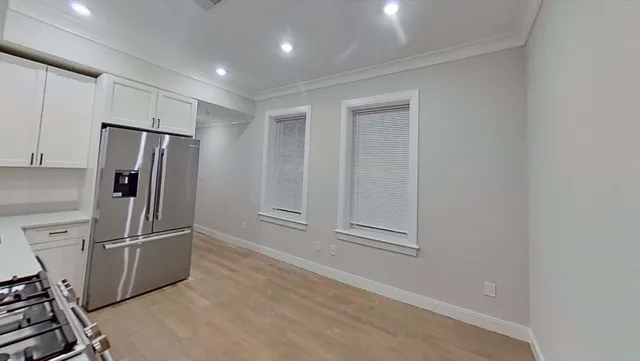 a view of a refrigerator in kitchen and wooden floor