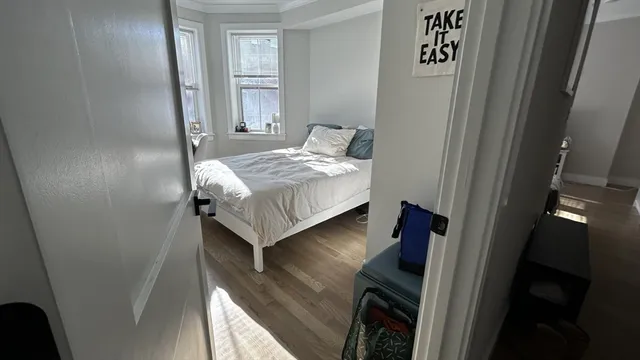 a bedroom with a bed and a large window