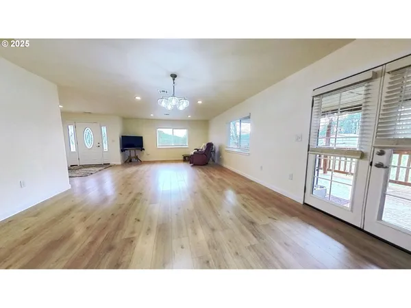 a open hall with wooden floor and windows